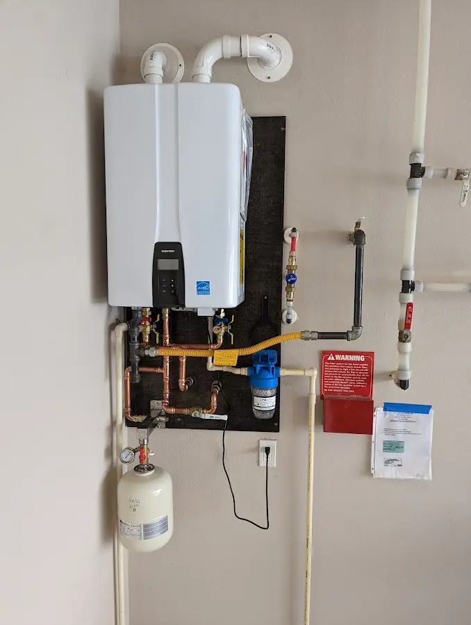 Professional plumber installing copper piping in a Lee home